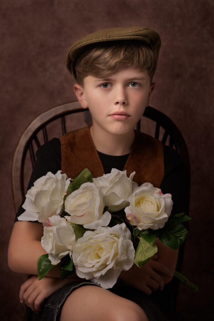 Titanic styled fine art portrait of a young boy holding a bouquet of flowers